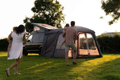 An image of a black campervan with a tailgate awning on the back.