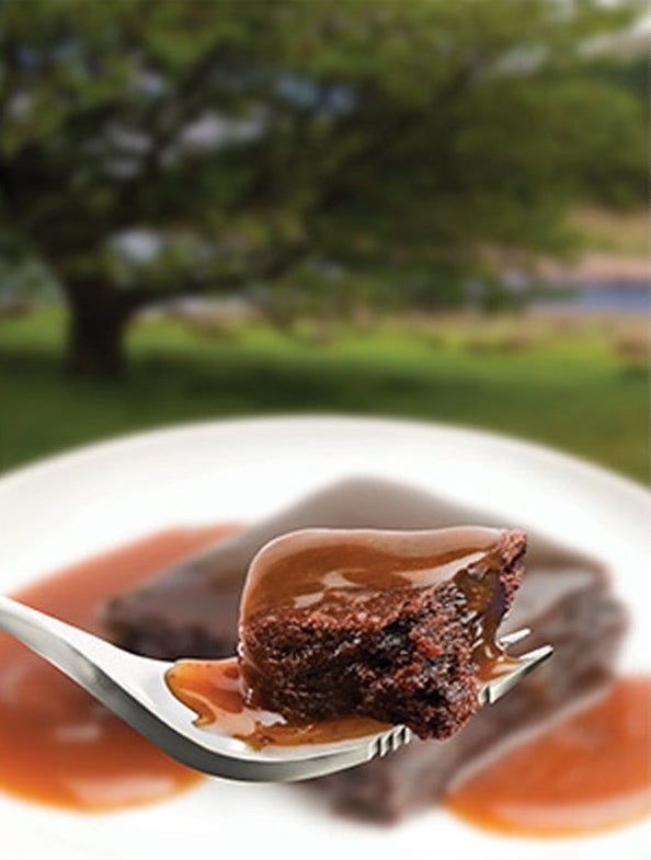 Close up of ready-to-eat salted caramel chocolate brownies on a fork.