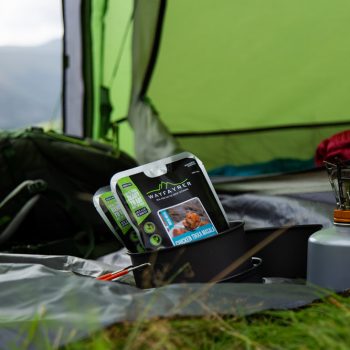 Ten set up with a gas camping stove. Packets of ready-to-eat food in a pan.