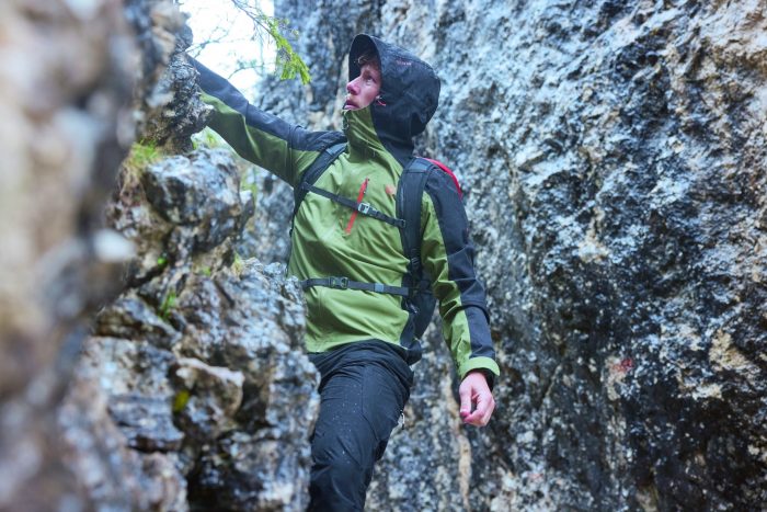 Man mountaineering walking between two boulders