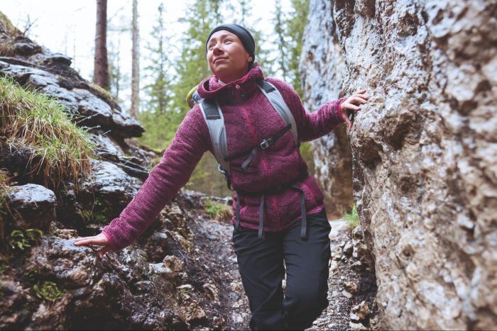 Woman hiking between two boulders