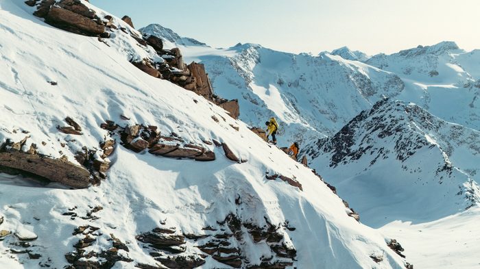 Two people climbing a snowy mountain